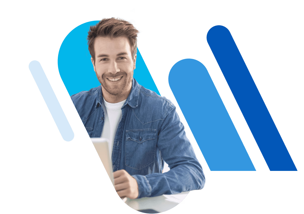 Junger Mann, der vor Laptop sitzt und ein blaues Jeanshemd trägt